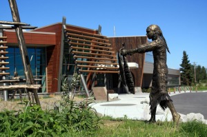 Photos by Patrice Kohl, for the Redoubt Reporter. A “Łuq’a Nagh Ghilghuzht” sculpture by Joel Isaak depicts traditional Dena’ina life at fish camp outside the Kenaitze Indian Tribe’s new Dena’ina Wellness Center in Old Town Kenai.